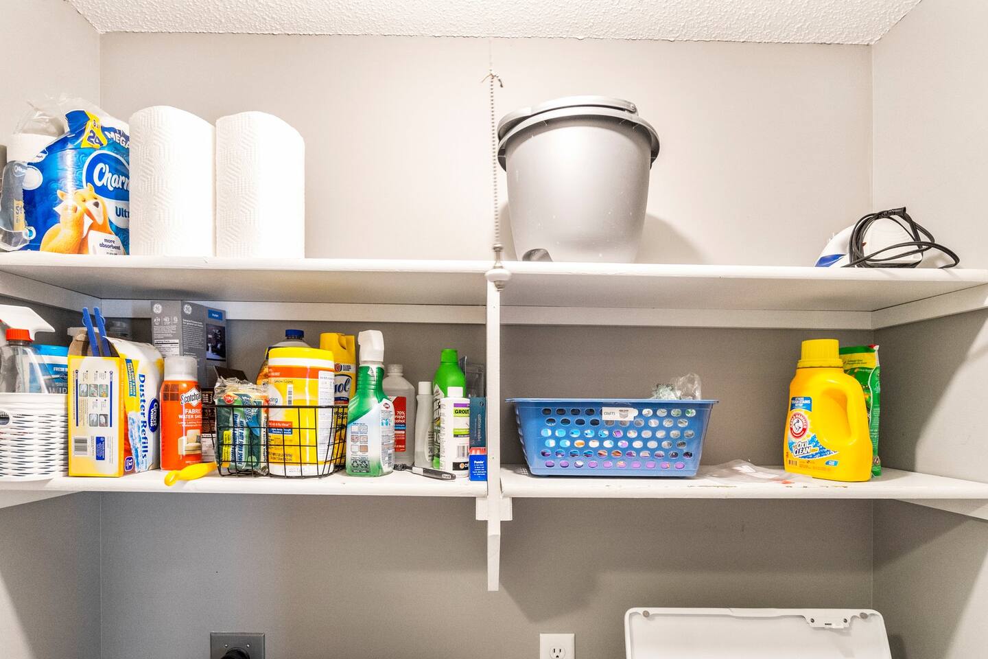 Well-stocked laundry shelves featuring detergent, cleaners, and paper products.