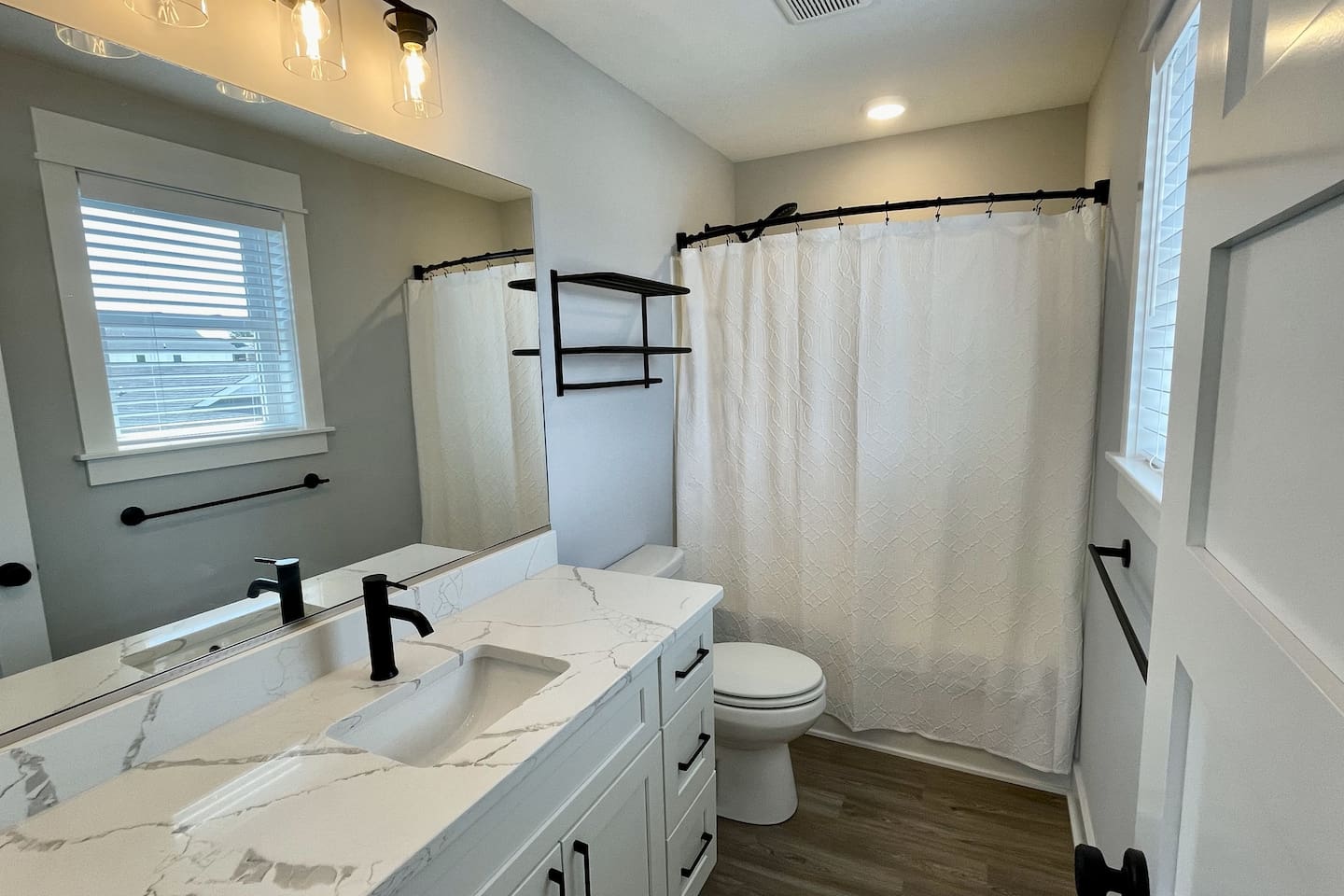 Privacy and convenience. This bright, modern ensuite bathroom attached to the second King room features sleek fixtures and a clean, spa-like feel.