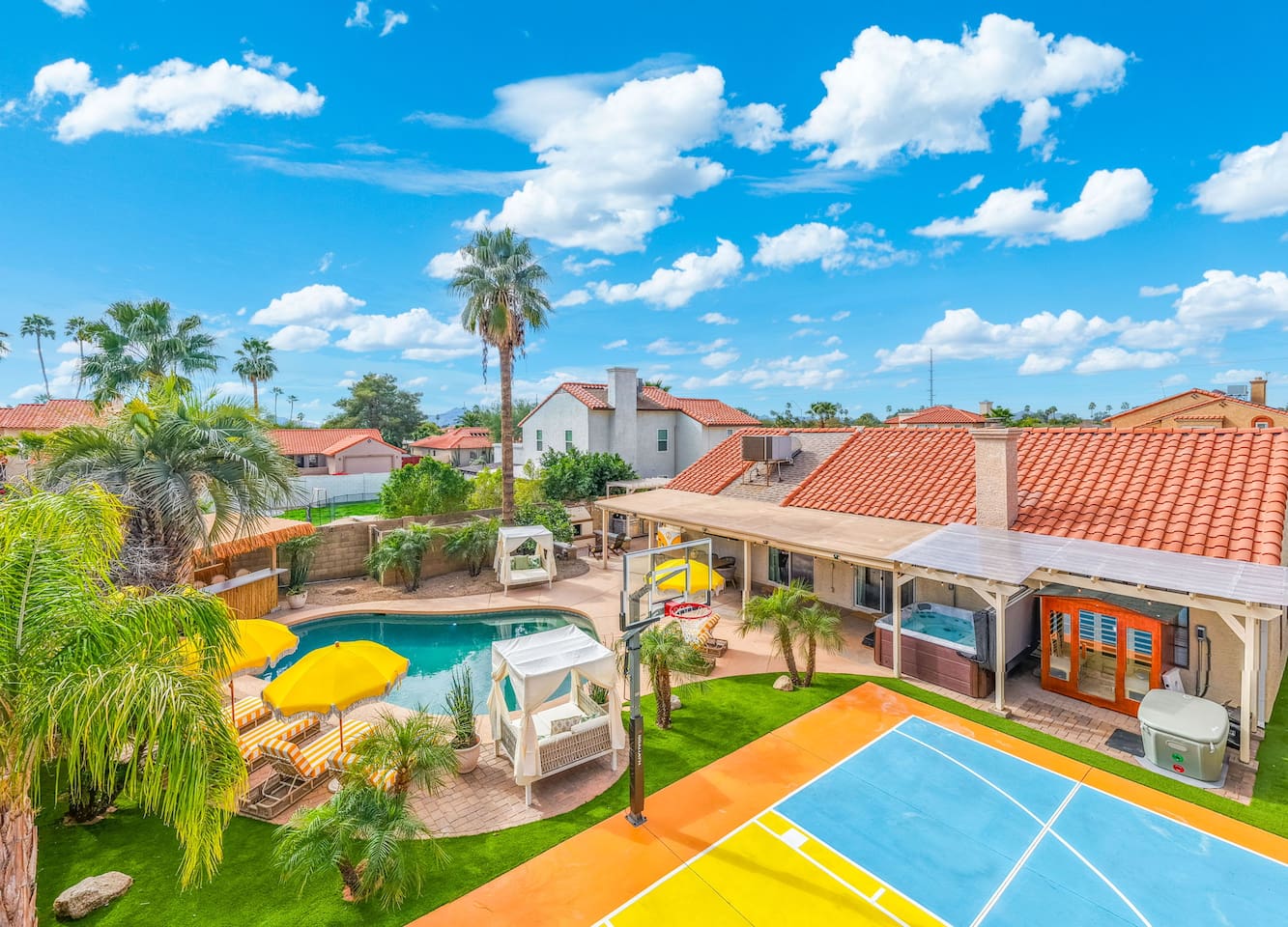 Expansive backyard resort with pool, spa, basketball court, and lush landscaping—an entertainer's dream with desert views.