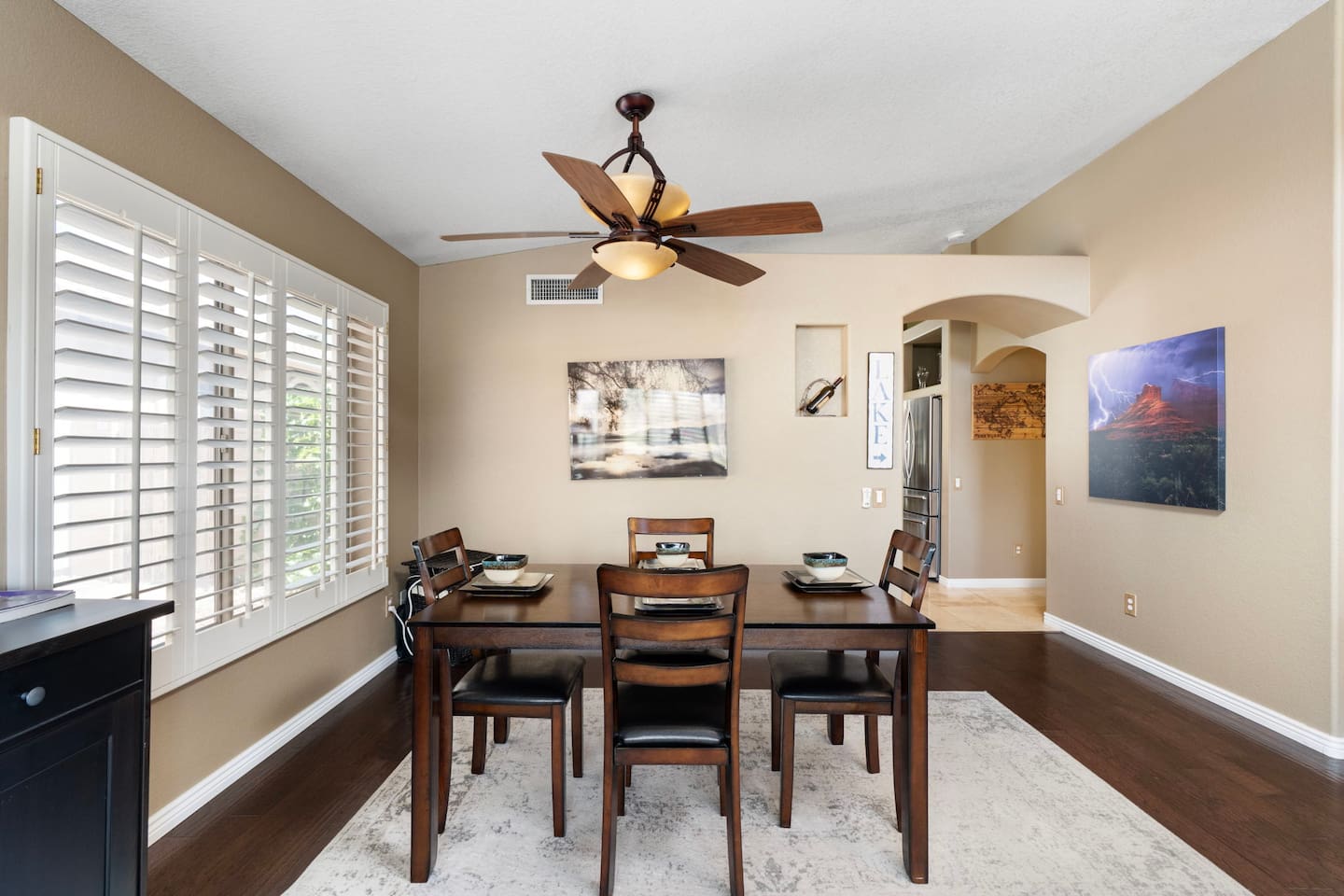 The dining area is bathed in natural light through plantation shutters, setting a warm and relaxed mood for every meal — whether it's a quick breakfast or a leisurely dinner.