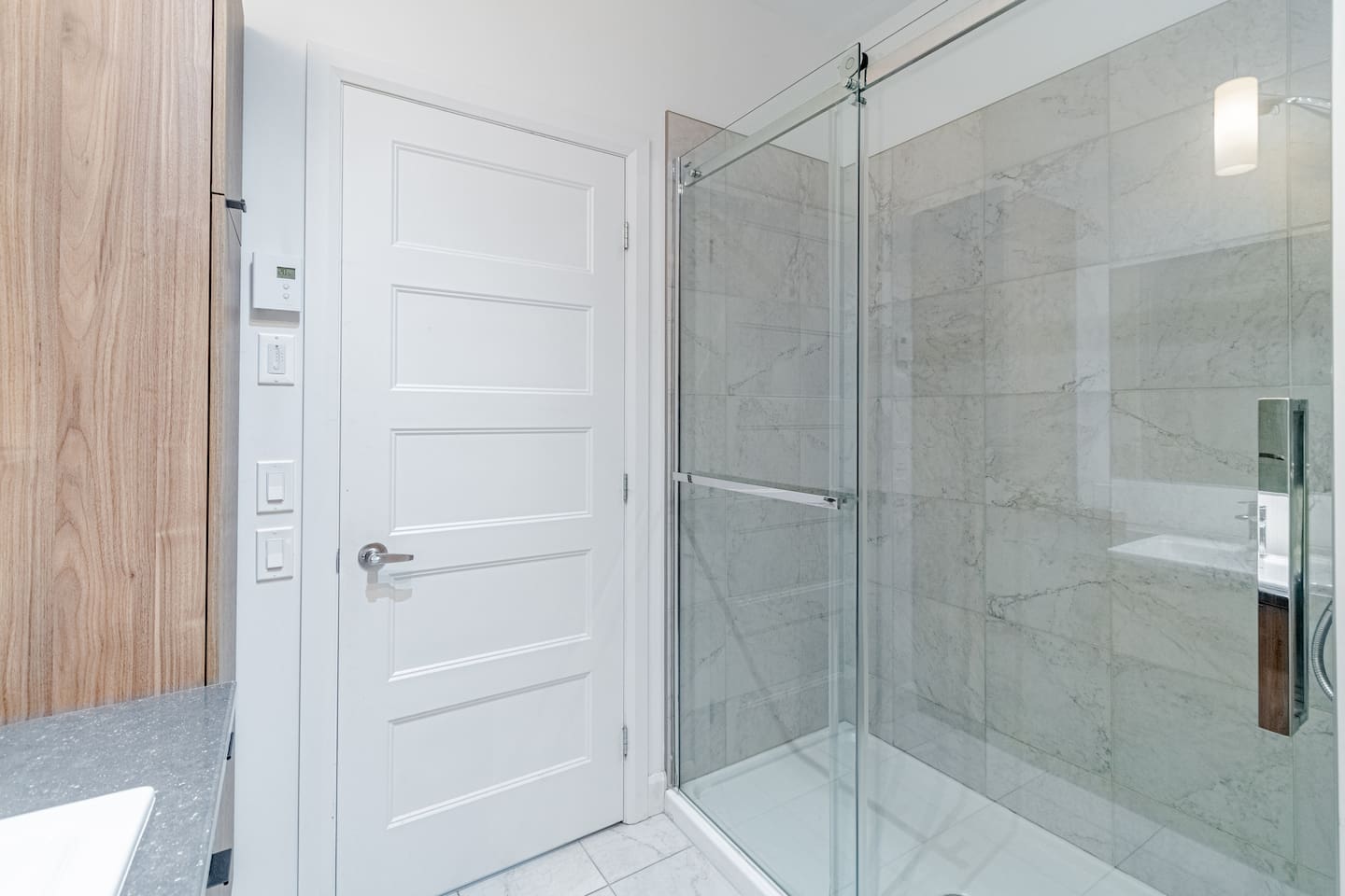 Salle de bain moderne et complète avec douche.