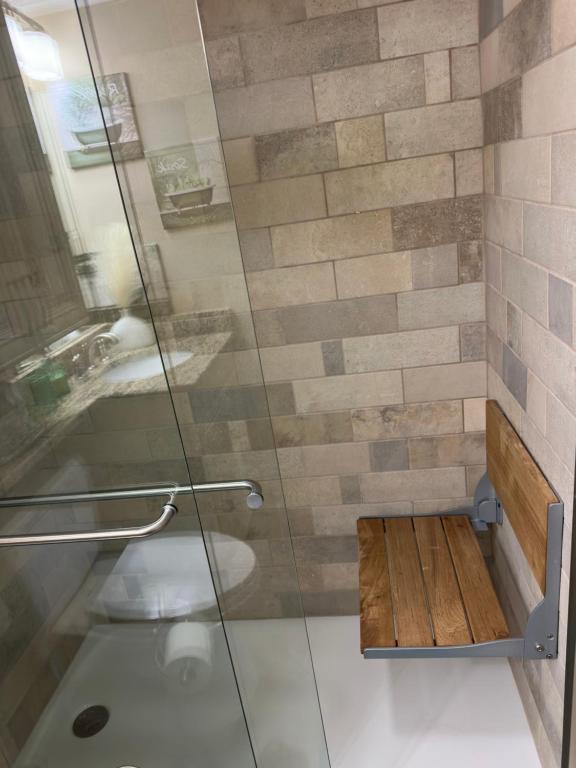 The bathroom features a 24-inch accessible entry and is equipped with a wall-mounted shower chair for added comfort and convenience.