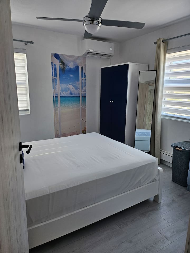 Queen size bed, new mattress, full length mirror, darkening curtains, remote controlled A/C, ceiling fan, and wardrobe