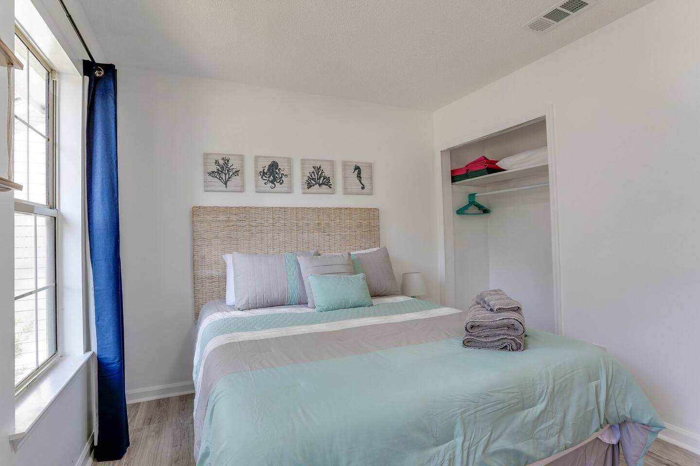 Bright and inviting, the second bedroom features a cozy queen bed, a convenient desk, and large windows that fill the space with natural sunlight.