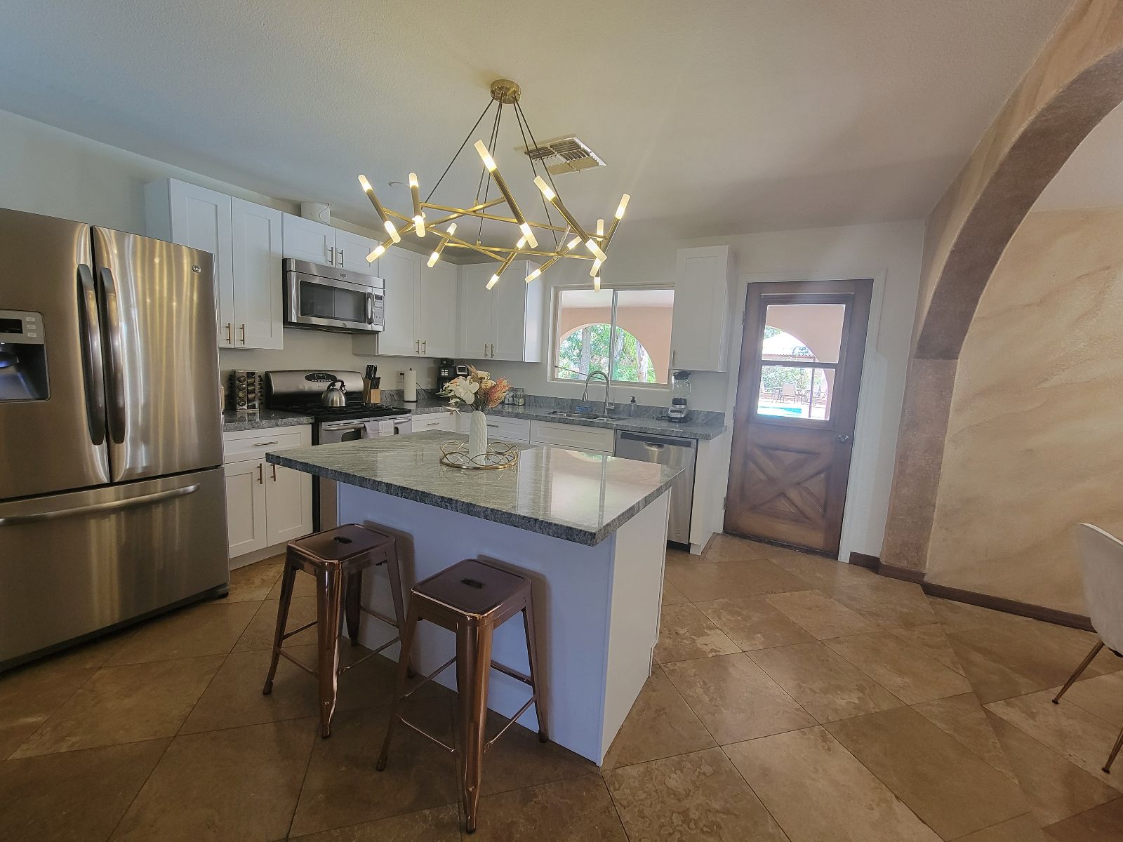 This modern kitchen features stainless steel appliances, sleek granite countertops, and a central island perfect for morning coffee or evening cocktails.