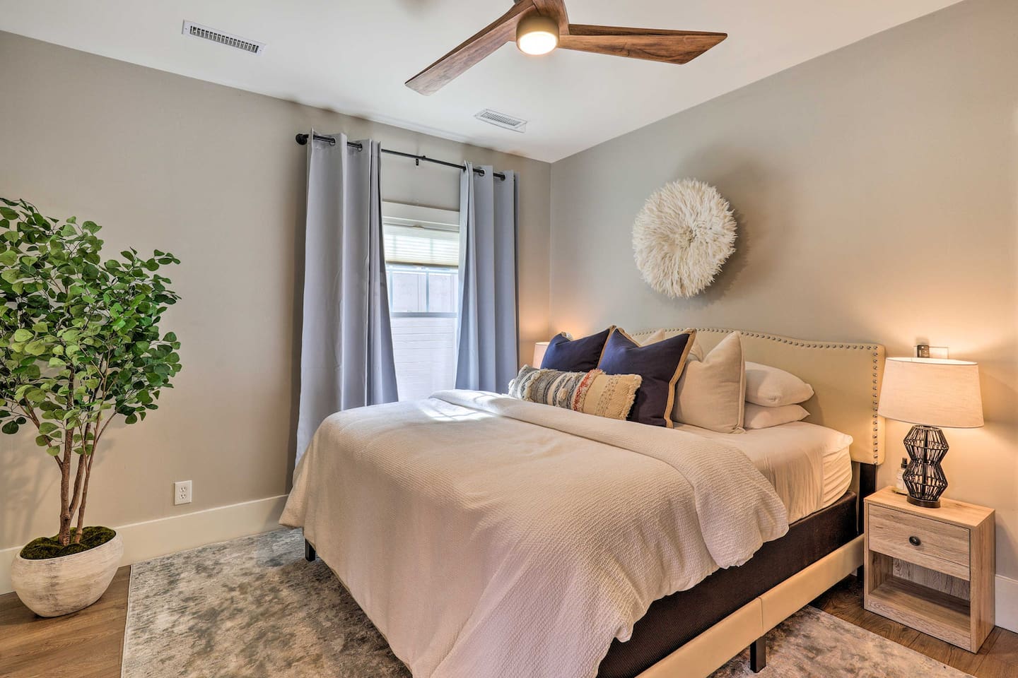 Crisp linens and a statement headboard set the tone for a restful night's sleep.