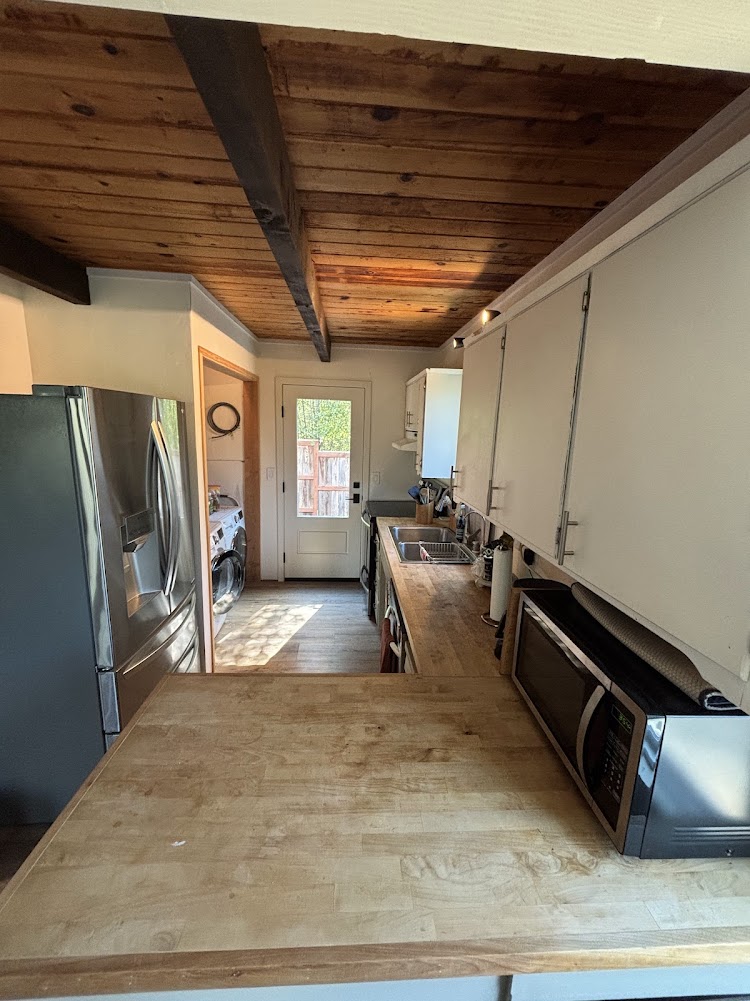 Kitchen, with washer dryer back left.  Door to small back deck and yard.