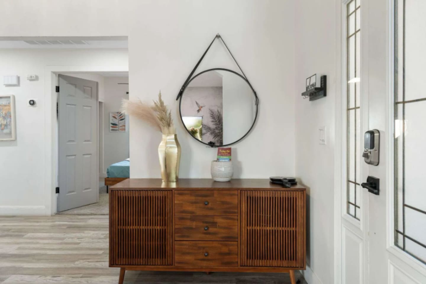 Bright, open entryway with designer mid-century console, statement mirror, and clean modern aesthetic.