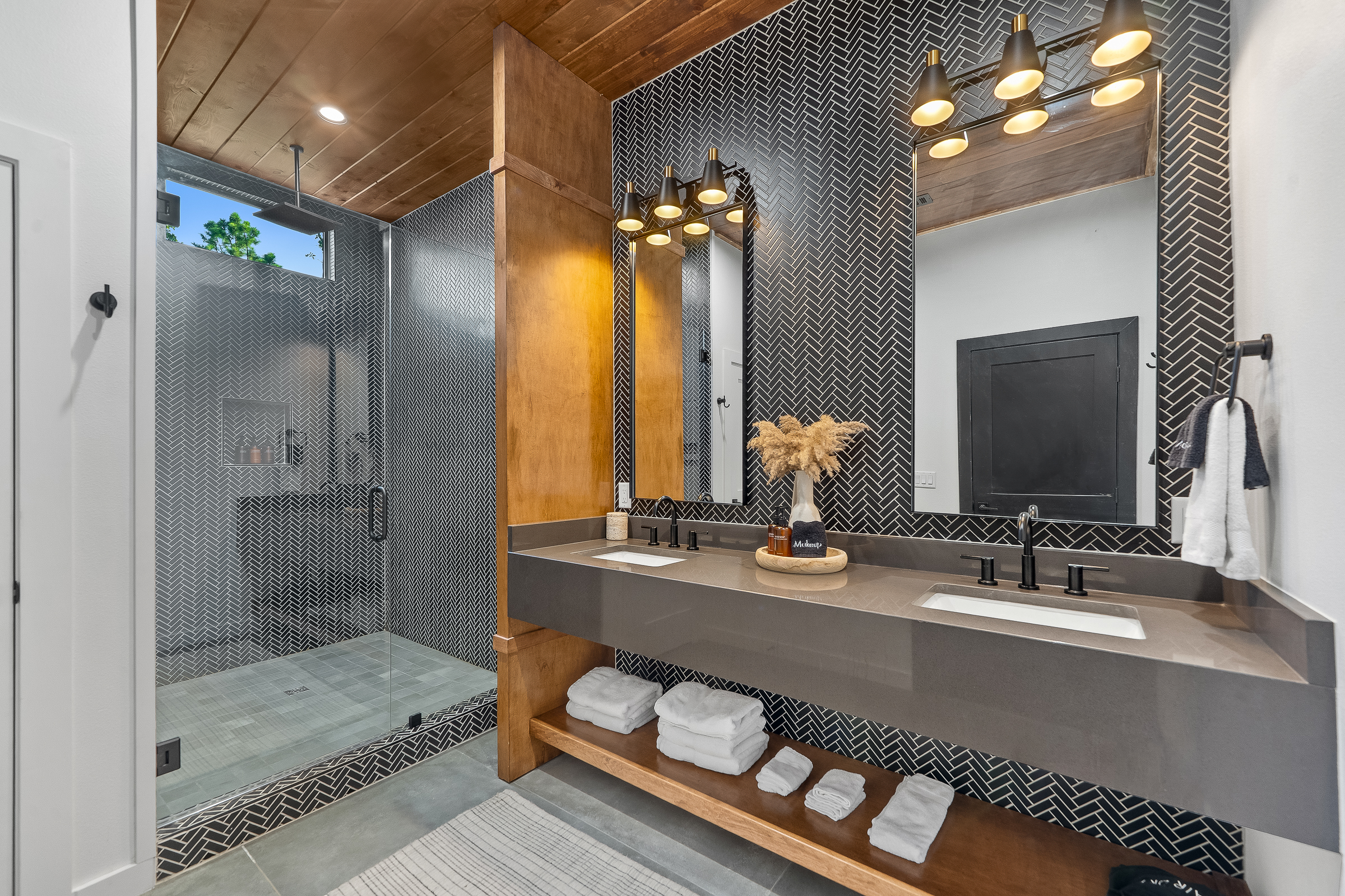 Semi-private bathroom for those staying in the Bunk room. This bathroom features modern teak finishes, stunning modern design, and an oversized rain shower with dual shower heads. 