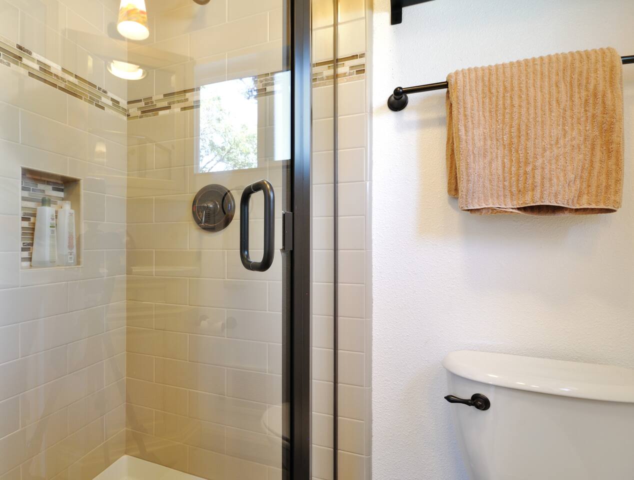 Modern shower w/ black fixtures & clean tile