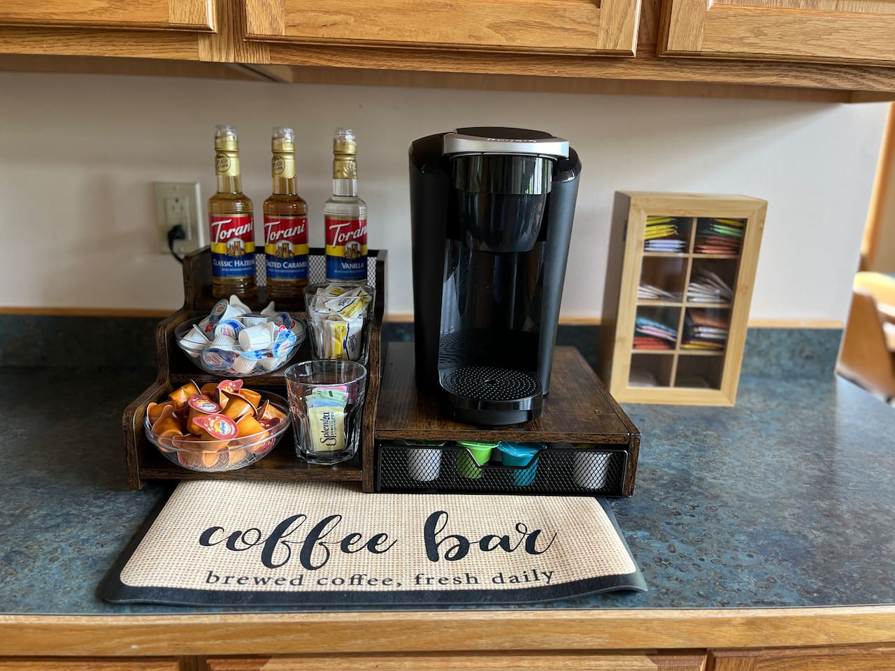 Coffee bar includes Keurig coffee maker, syrups, creamers, sugar, and sugar alternatives.