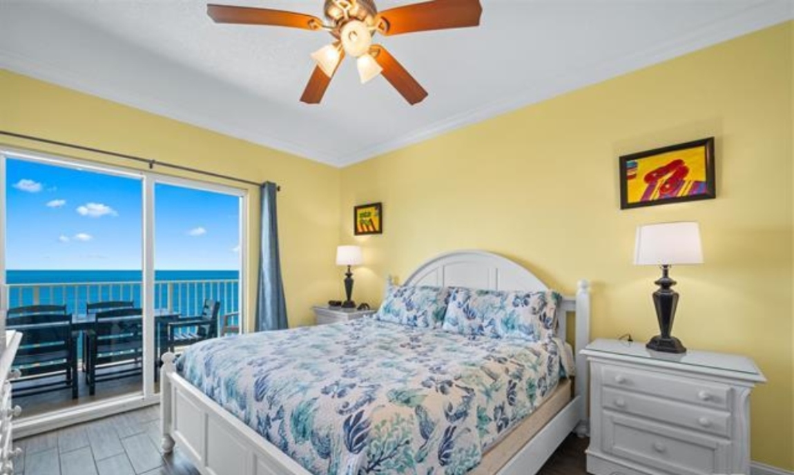 Primary Bedroom With Direct Gulf View, King Size Bed, Dresser With Mirror, 2 Nightstands, ceiling fan, double closet, 50" wall mounted Smart TV, Direct Balcony Access & Ensuite Full Bathroom