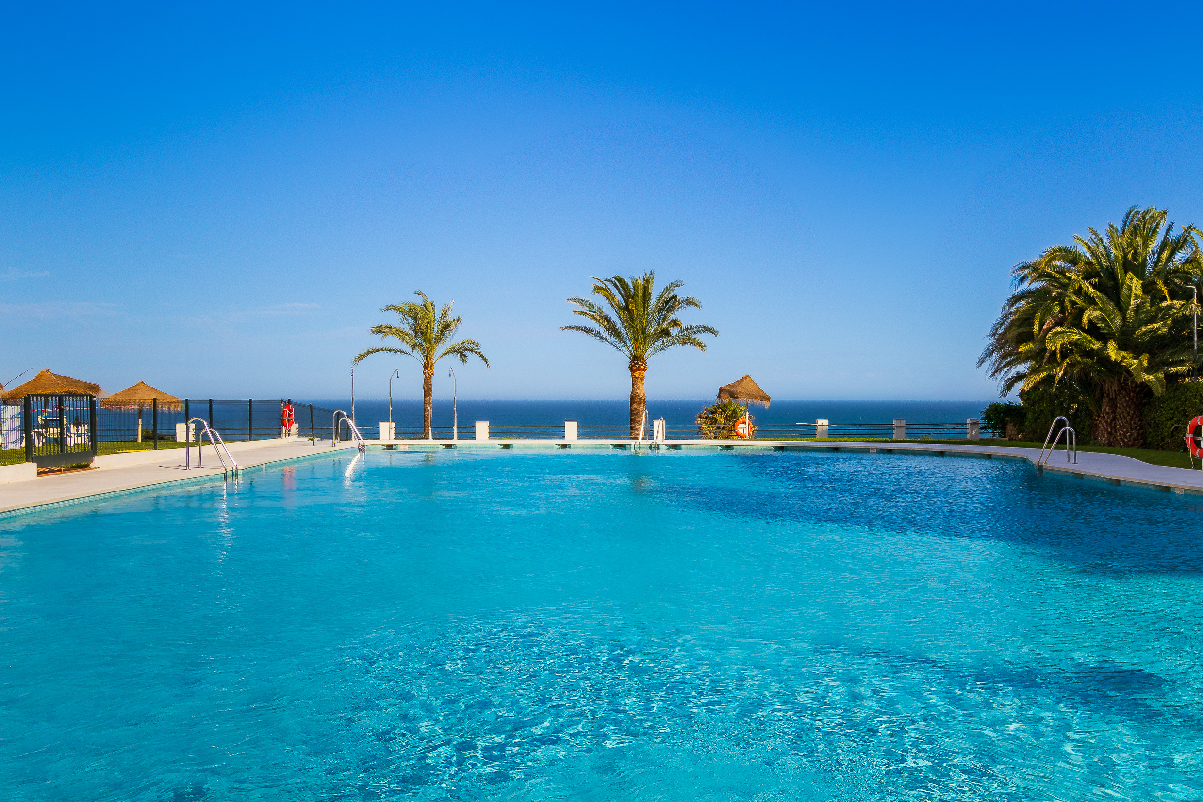 Shared beachfront pool with sea views