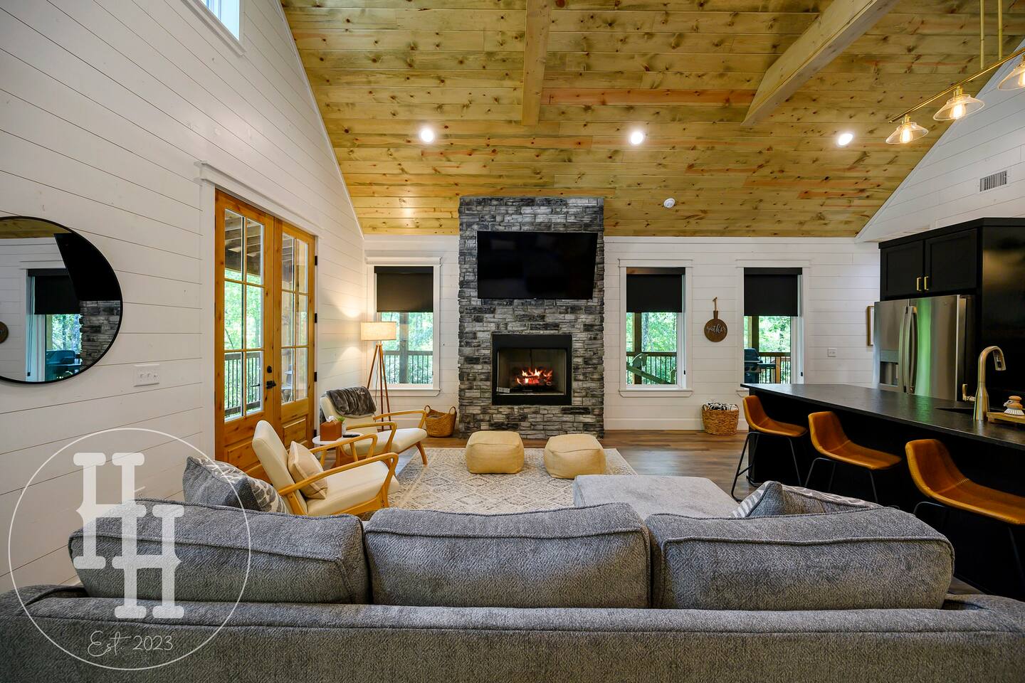 Living area with couch, designer chairs, gas fireplace, and smart TV.