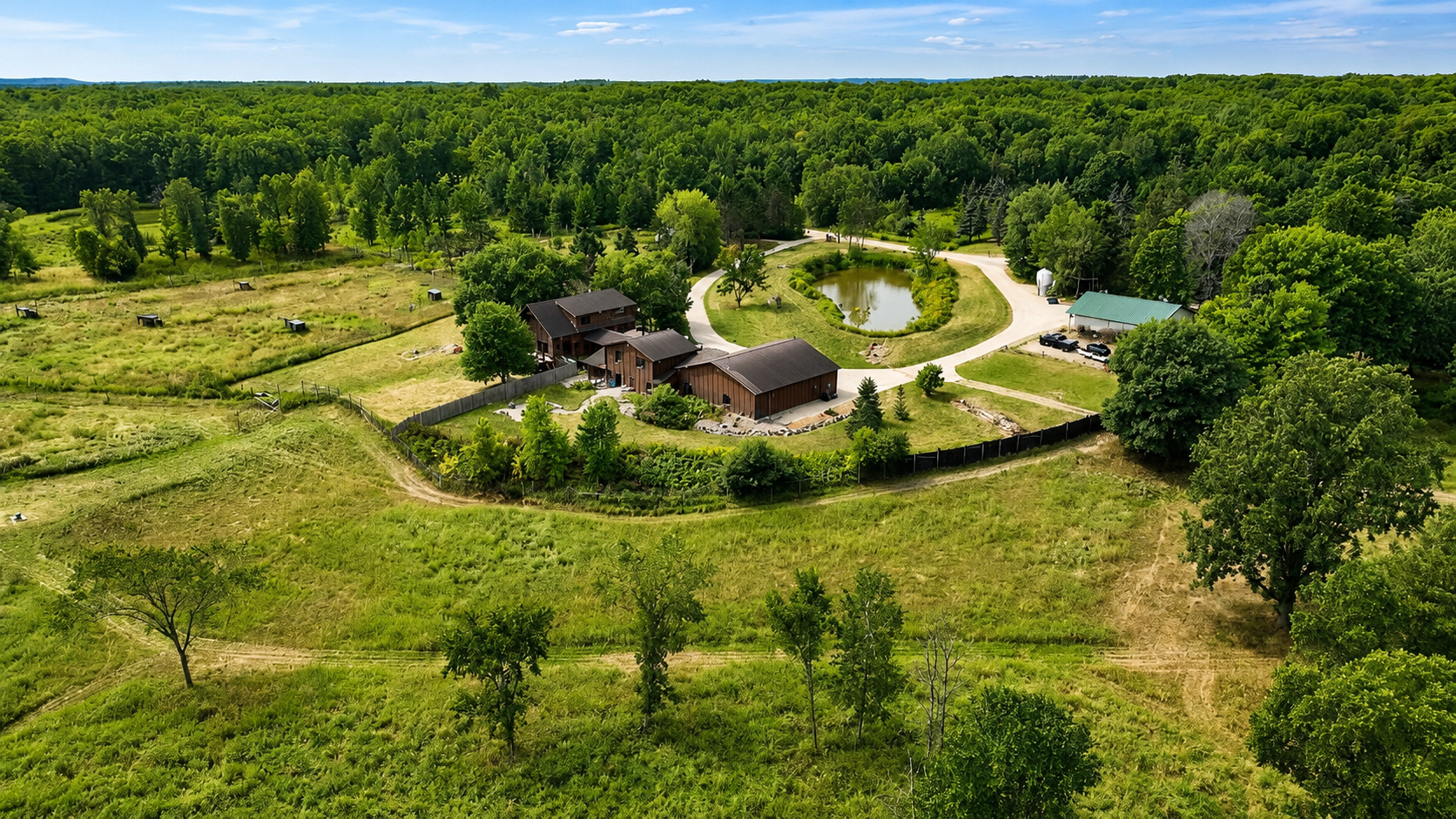Sweeping aerial view shows the lodge tucked into the beautiful Birchwood countryside with plenty of open space, scenic Northwoods surroundings, and convenient access for outdoor adventure.