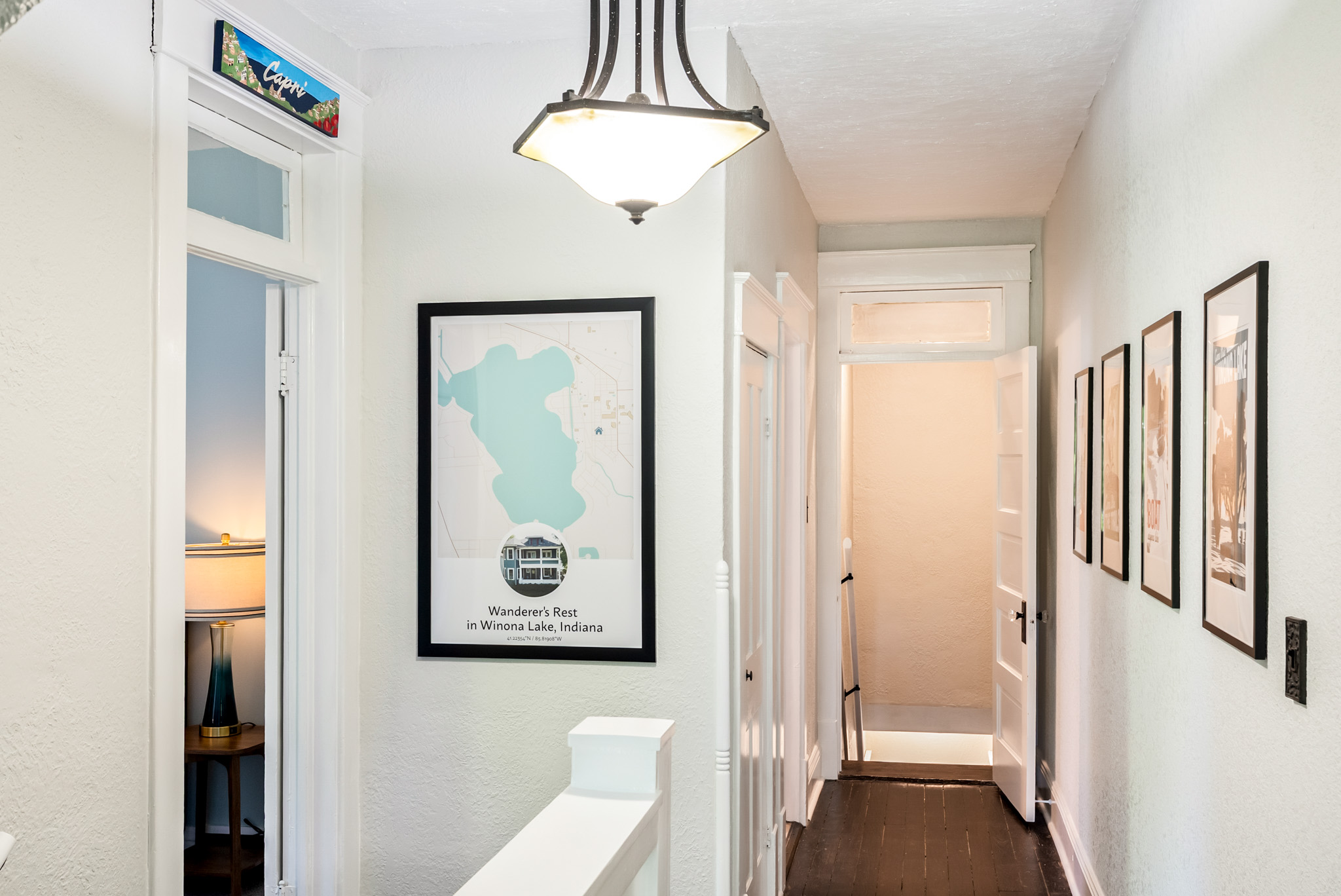 Welcome to the adventure level. The upper-floor hallway features custom local maps and vintage travel-inspired decor connecting the upper bedrooms.