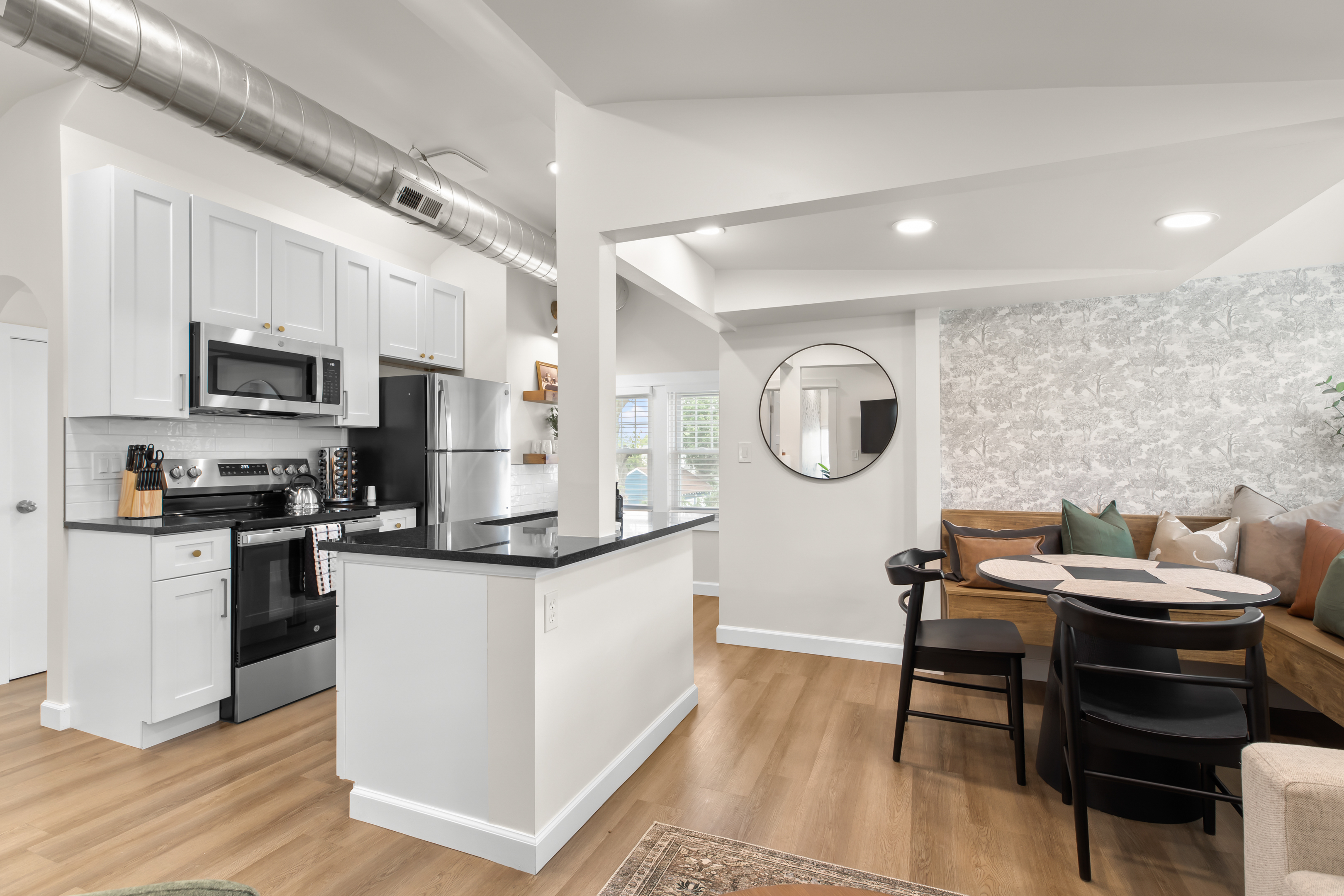 Modern open-concept kitchen and dining nook with stylish banquette seating—perfect for cooking, dining, and relaxing in comfort.