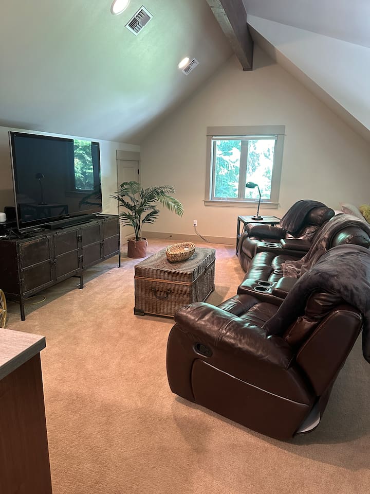 The entertainment room features leather-style recliners that seat six, perfect for movie nights on the large screen smart TV.