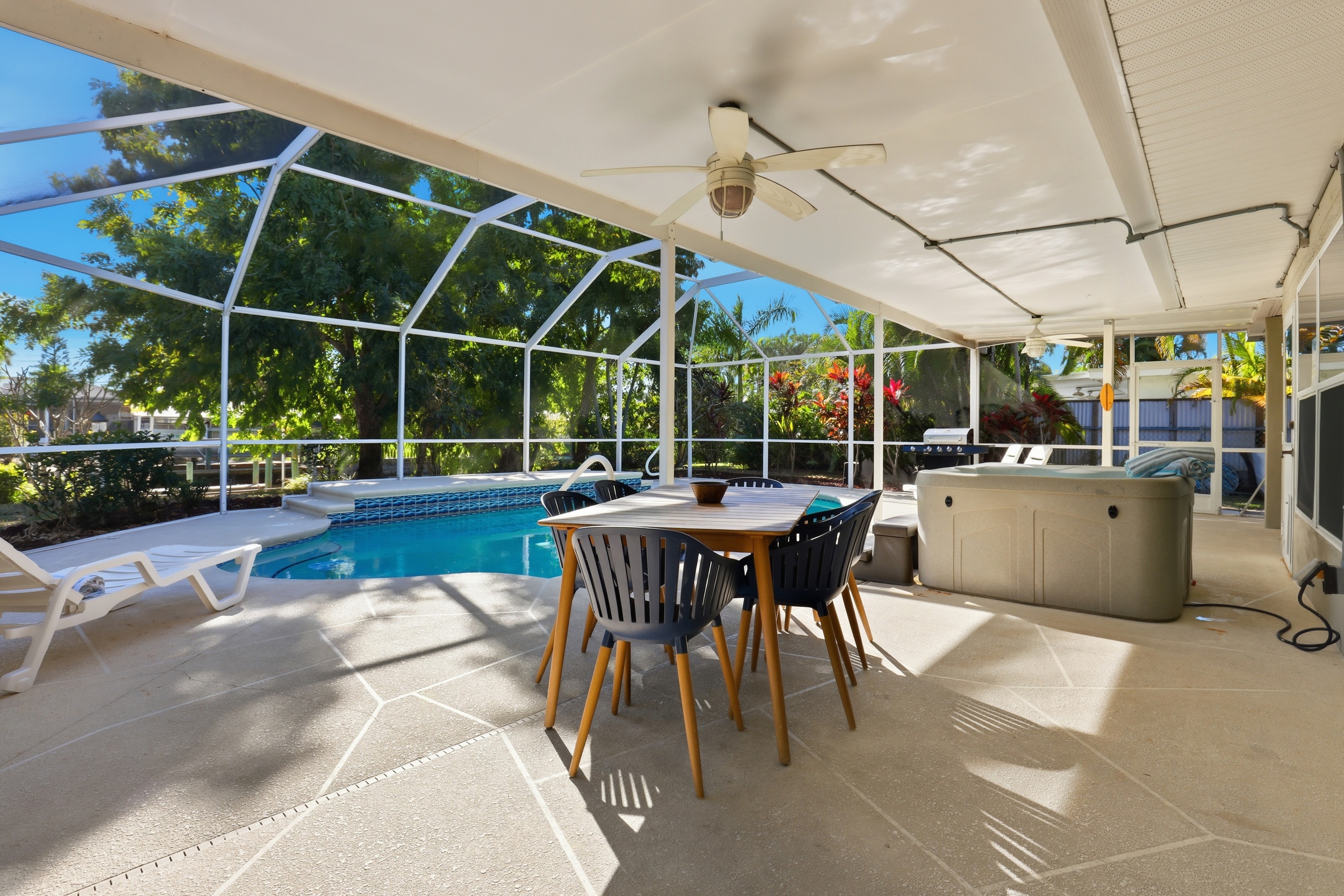 Lanai with dining table, loungers, grill and hot tub