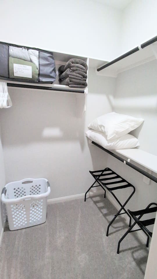 Large primary closet with extra pillows & towels, luggage racks, hangers and a laundry hamper.  Bedding for the full sized sofa bed also included. 