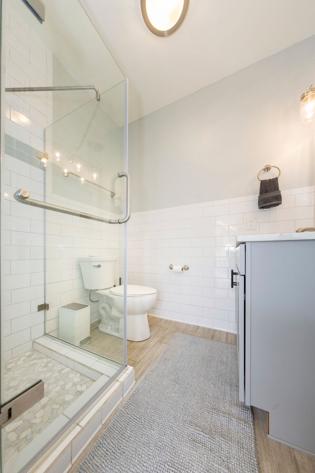 Bathroom 2 (Downstairs) is a Bright, modern bathroom with a walk-in glass shower and fresh, spa-like finishes