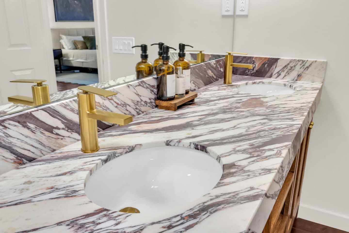 Guest bathroom with a double vanity sink and fully stocked essentials, including fresh towels, shampoo, conditioner, body wash, hand soap, and premium Ginger Lily Farms bath products for a comfortable, hotel-style experience.