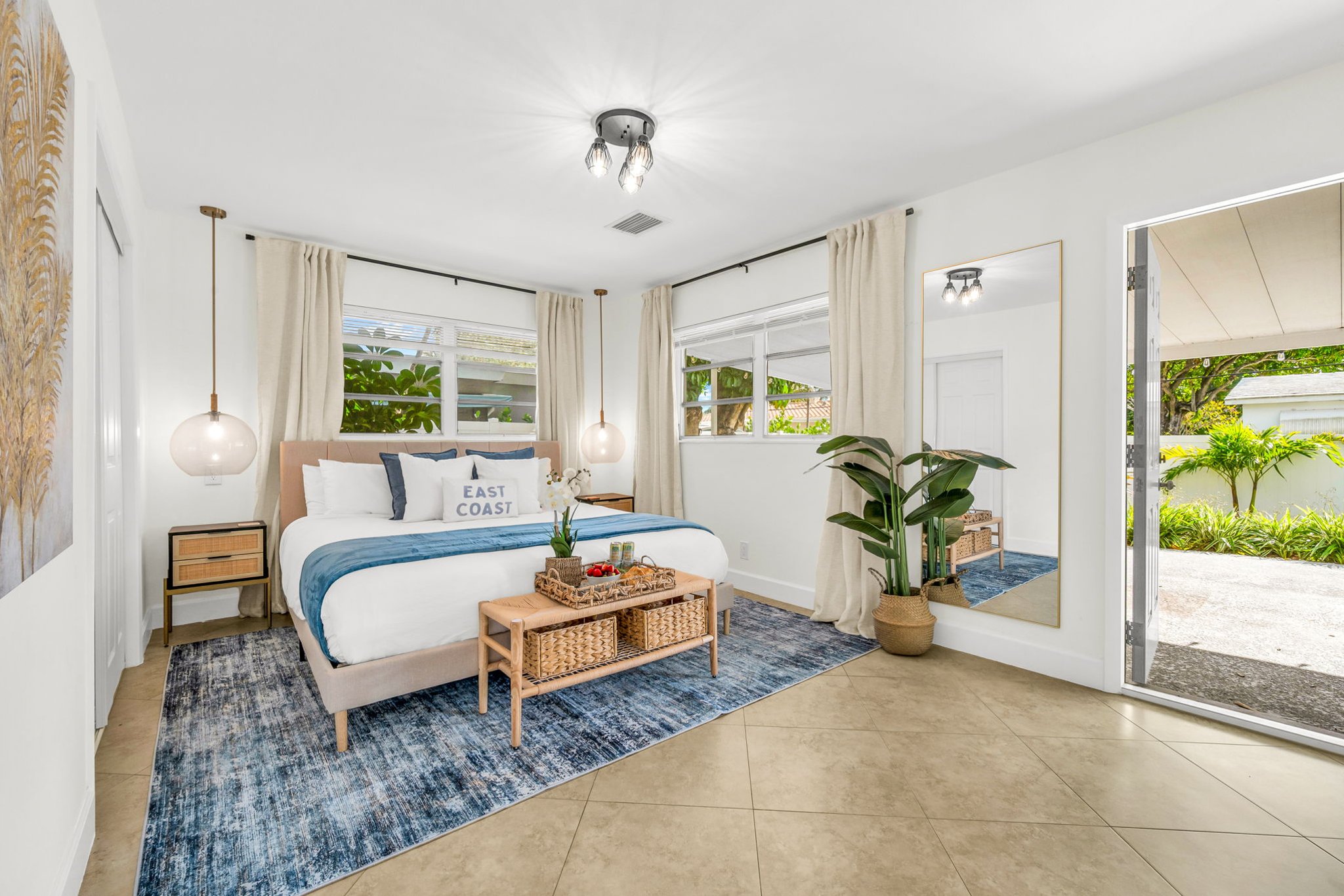 A bright and inviting primary suite featuring a hotel-quality king bed, dramatic pendant lighting, a sleek ensuite shower bath, and a Smart Fire streaming TV—your perfect private sanctuary.