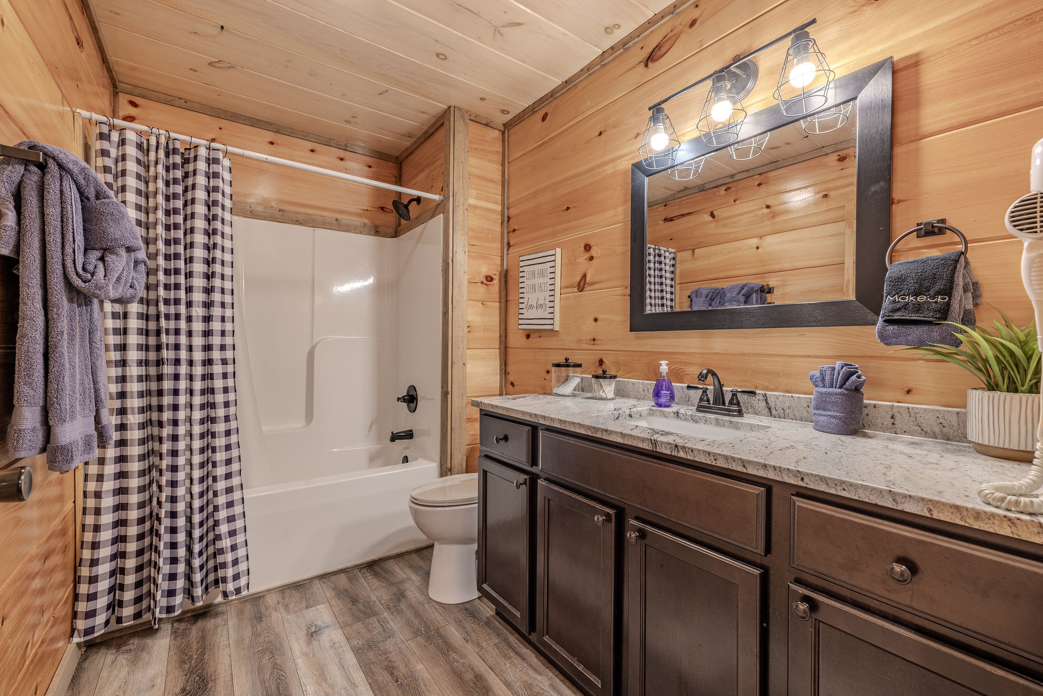 The shared full bathroom is convenient to the upstairs bedrooms and finished with clean cabin-style details.