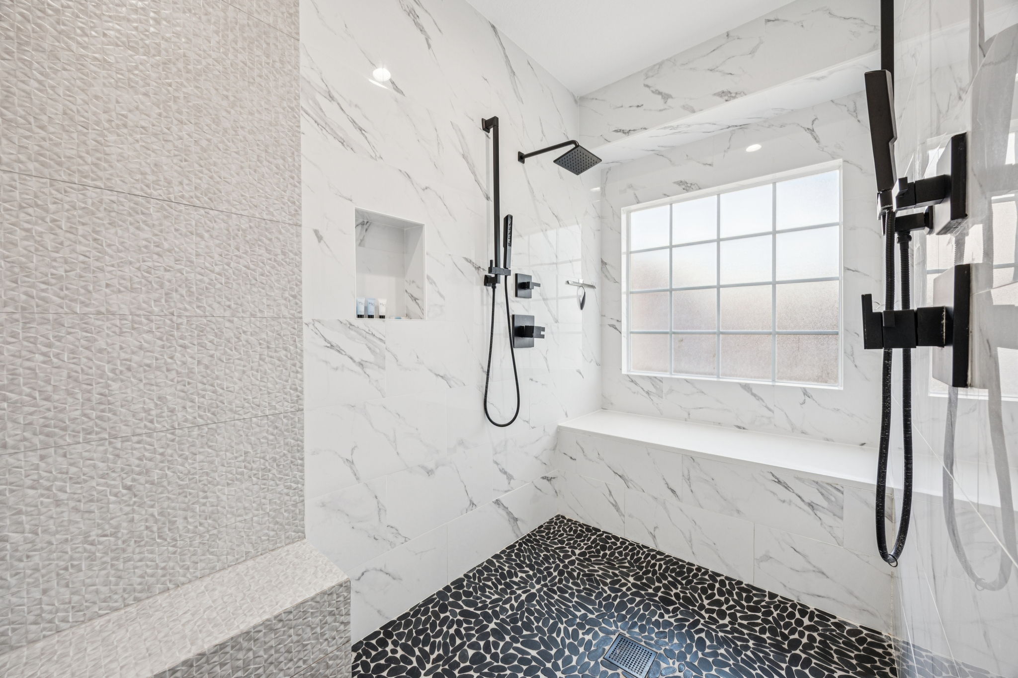 Spa-style bath with dual rain showers and dog-wash bench.