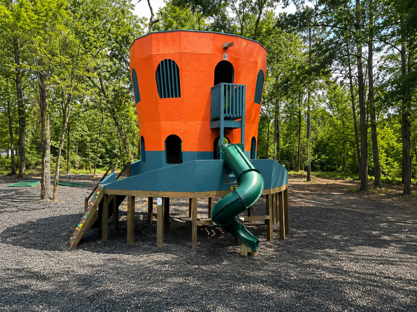 Playground Adventure: Brightly colored playhouse with slide, perfect for children’s fun!