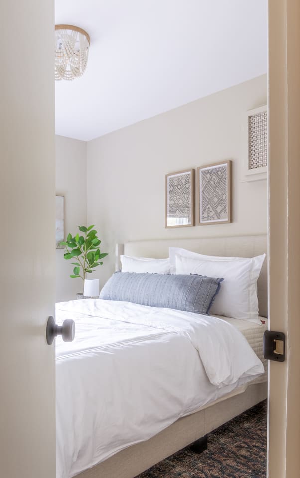 A glimpse of crisp linens and soft layers waiting just through the door.
