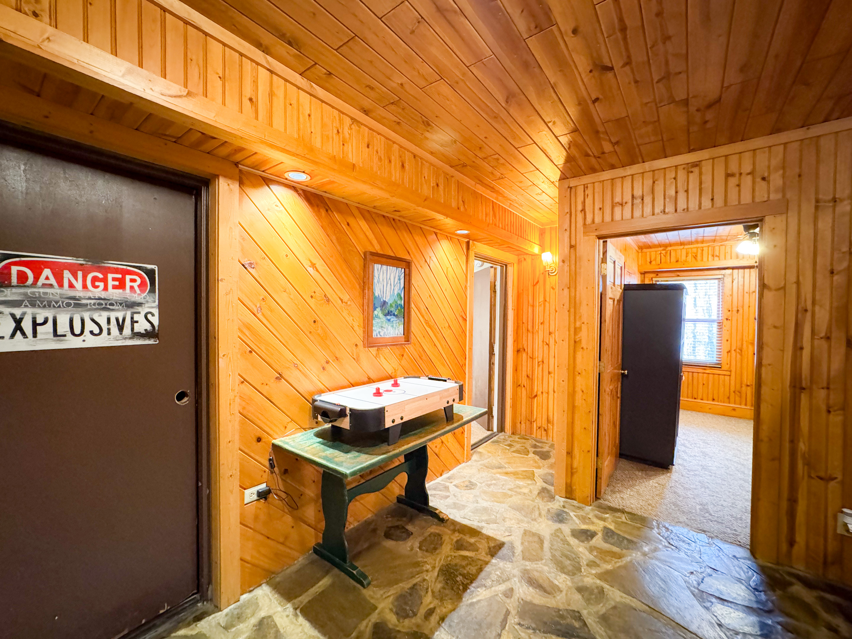 lower level foyer area. complete with tabletop Air hockey and dart board. There is a washer and dryer in the old ammo room - now labeled "Danger Explosives".