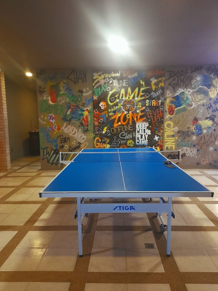 Challenge your friends to a match in this vibrant game room featuring a ping pong table.