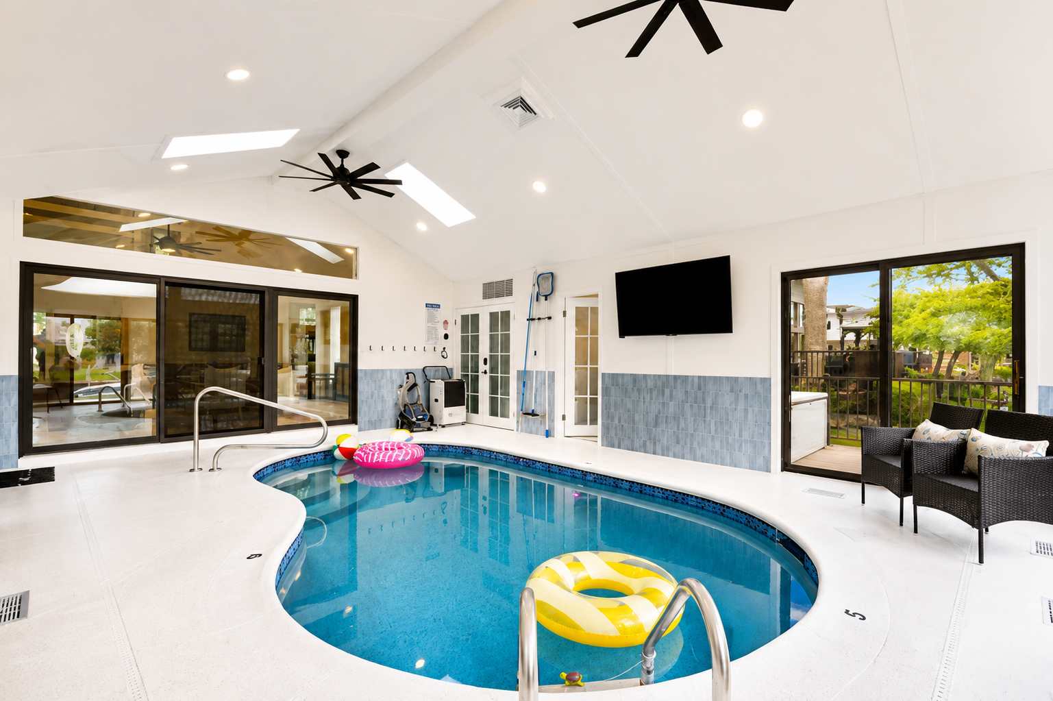 Year-round fun awaits in this stunning indoor heated pool room, featuring vaulted ceilings, skylights, abundant natural light, and a spacious resort-style design perfect for relaxing, swimming, and creating unforgettable memories with family and friends.