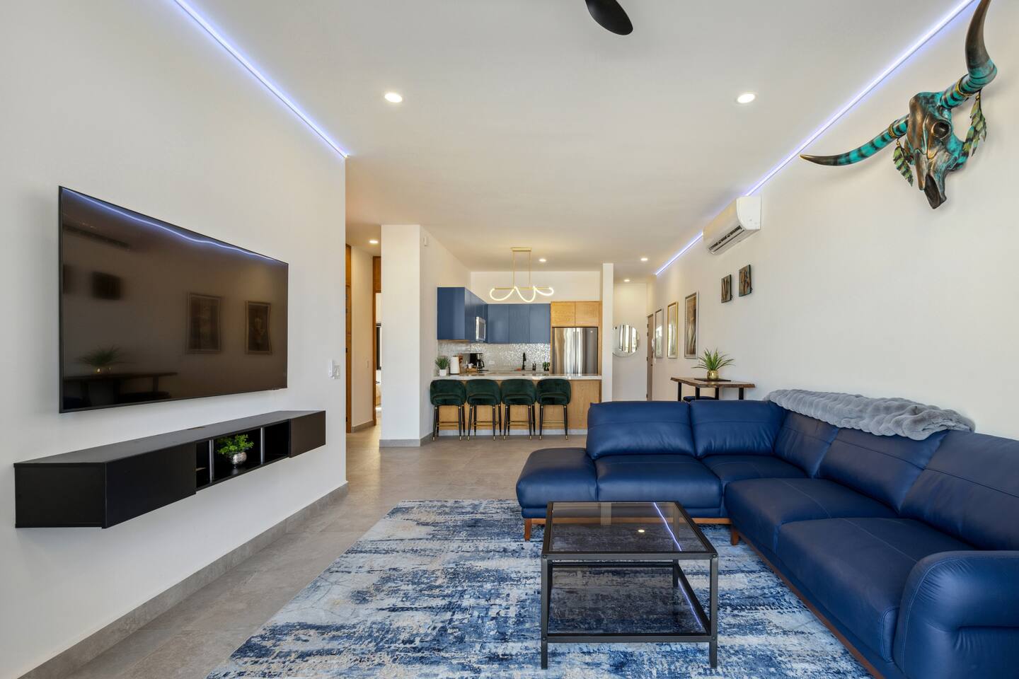 View the living room from the balcony, framed by a vibrant LED-lit perimeter wall.
