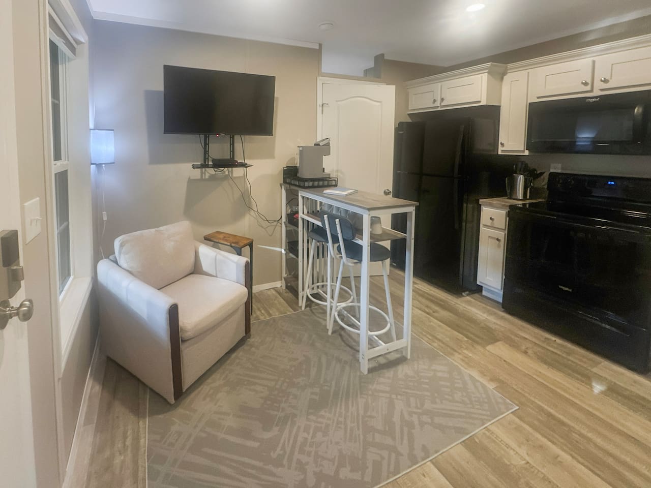 Smart tv with dvd player and dining area in living room. Full kitchen with refrigerator and stove.