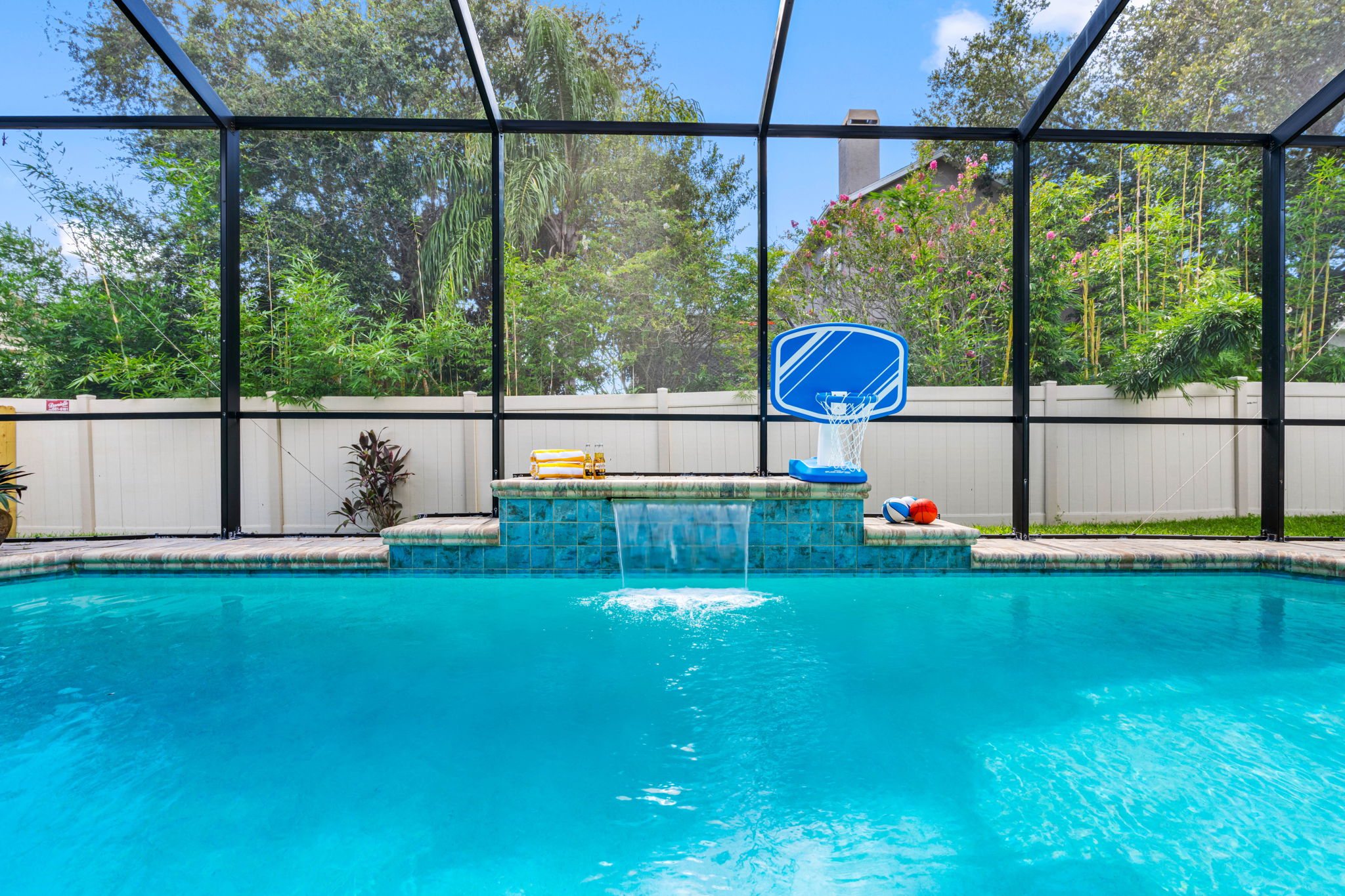 Enjoy the outdoors without the bugs! This screened-in pool area features serene water features, sports games, and ample space to swim or unwind.