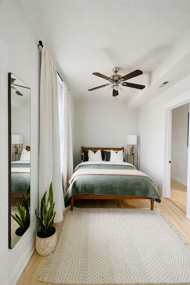 Spacious bedroom with modern decor and wood flooring.