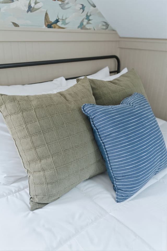 Close-up of plush bedding with soft linens and stylish accent pillows, creating a cozy and inviting sleep space.