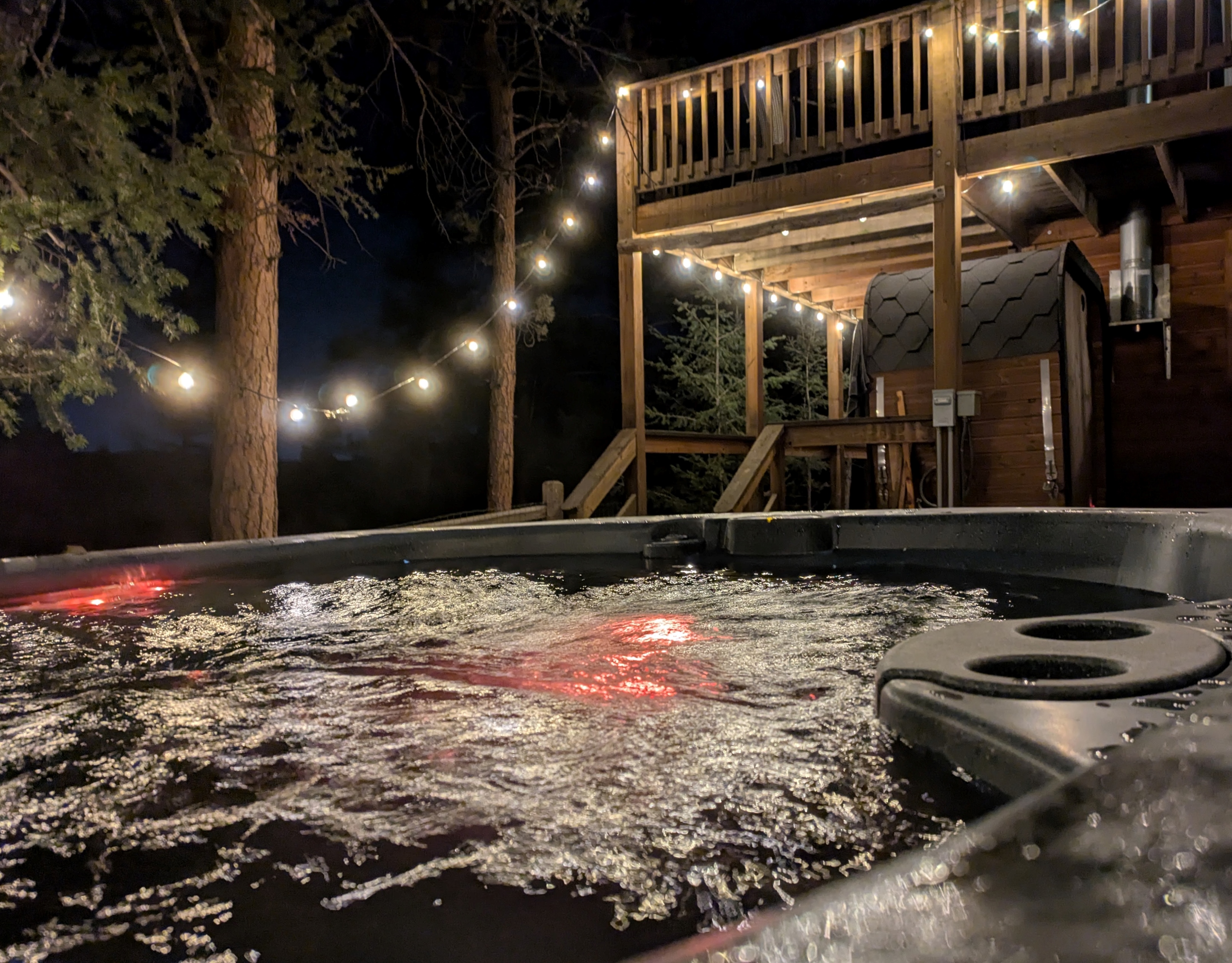 Private hot tub under the pines with string lights ✨—unwind with bubbling soaks, fresh mountain air, and peaceful forest views