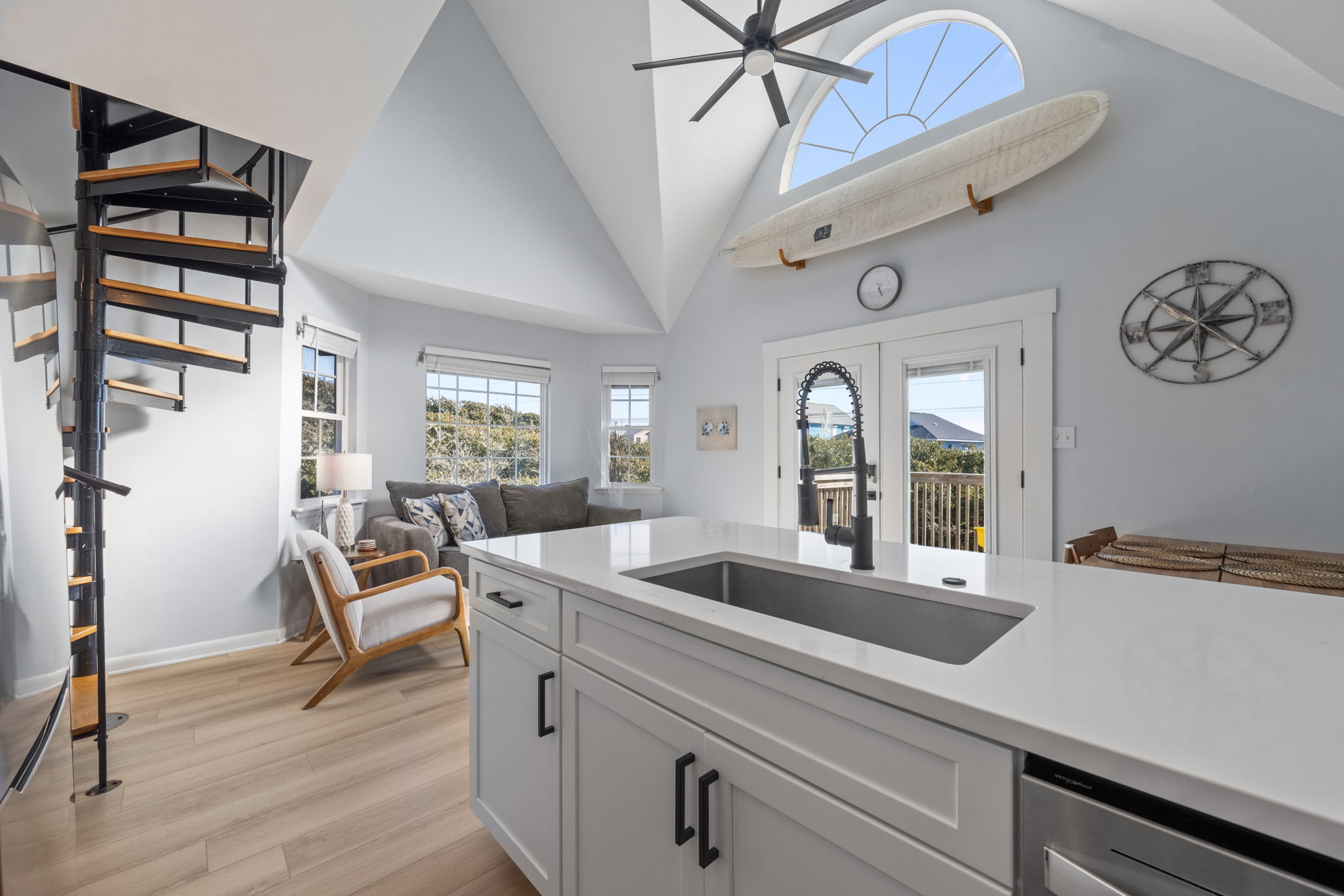 Open & updated living area featuring vaulted ceilings and expansive windows.