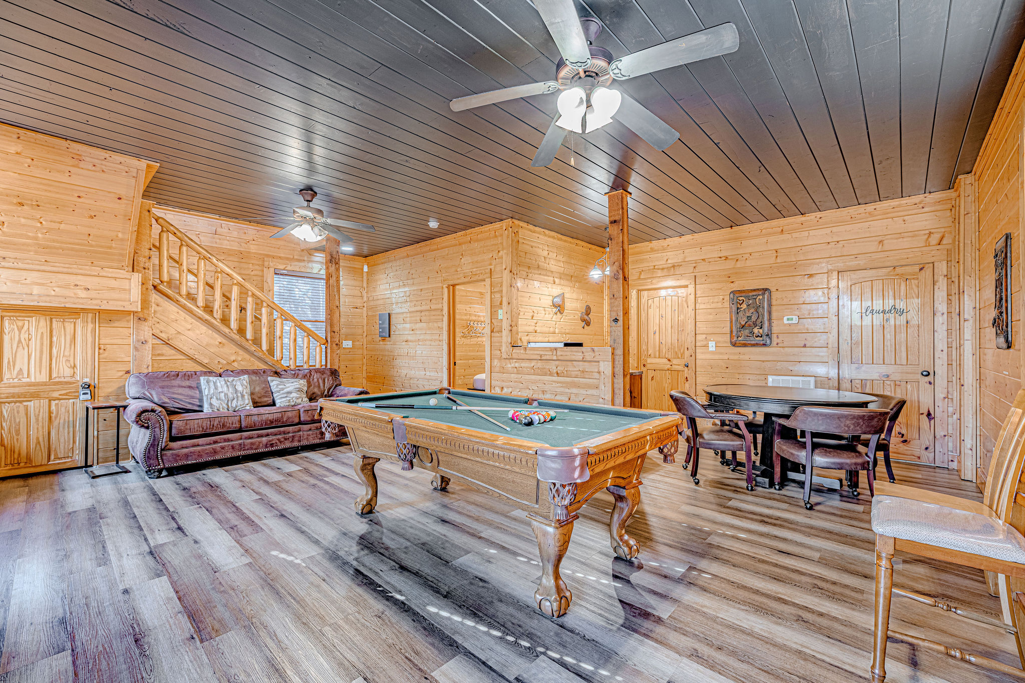 Enjoy playing pool in the lower level of the cabin. Carpet recently replaced with LVP flooring and ceiling painted dark grey to enhance the game room experience.