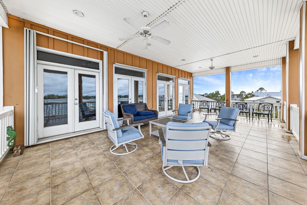 Expansive covered balcony with lounge seating and sweeping views of Little Lagoon