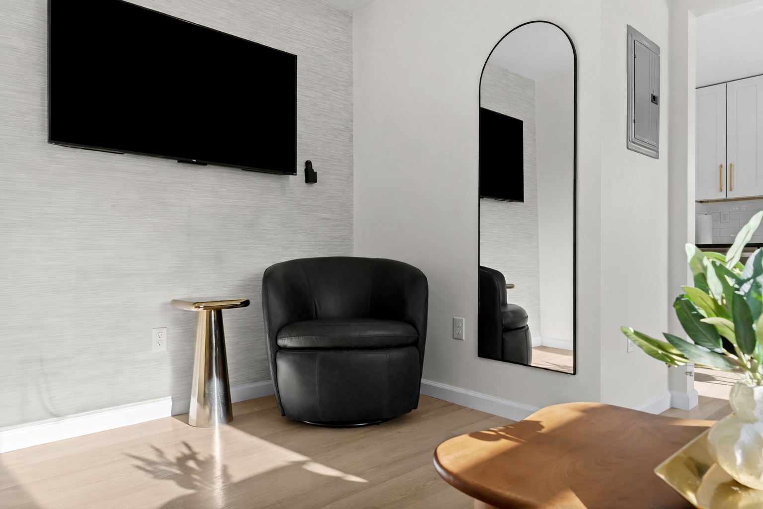 Stylish lounge nook with a smart TV, plush accent chair, and warm natural light—perfect for unwinding with a show or a quiet moment.