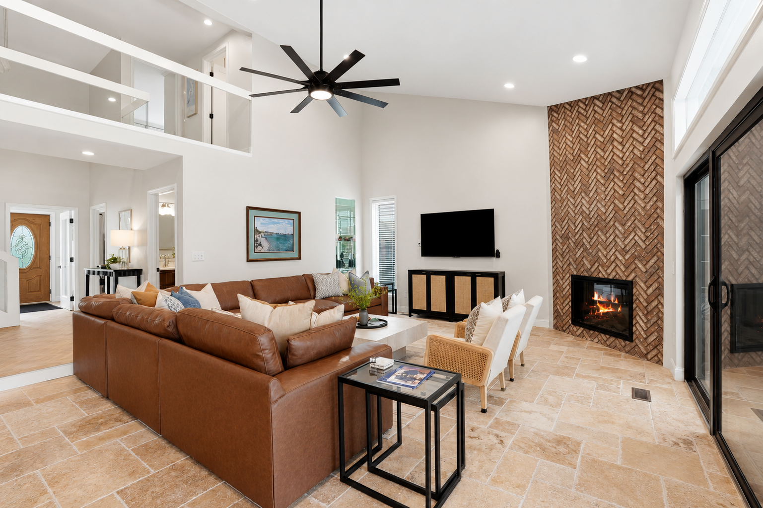 Spacious open-concept living room with a cozy sectional, modern fireplace, and high ceilings. Bright, stylish space ideal for relaxing, entertaining, and enjoying group stays.
