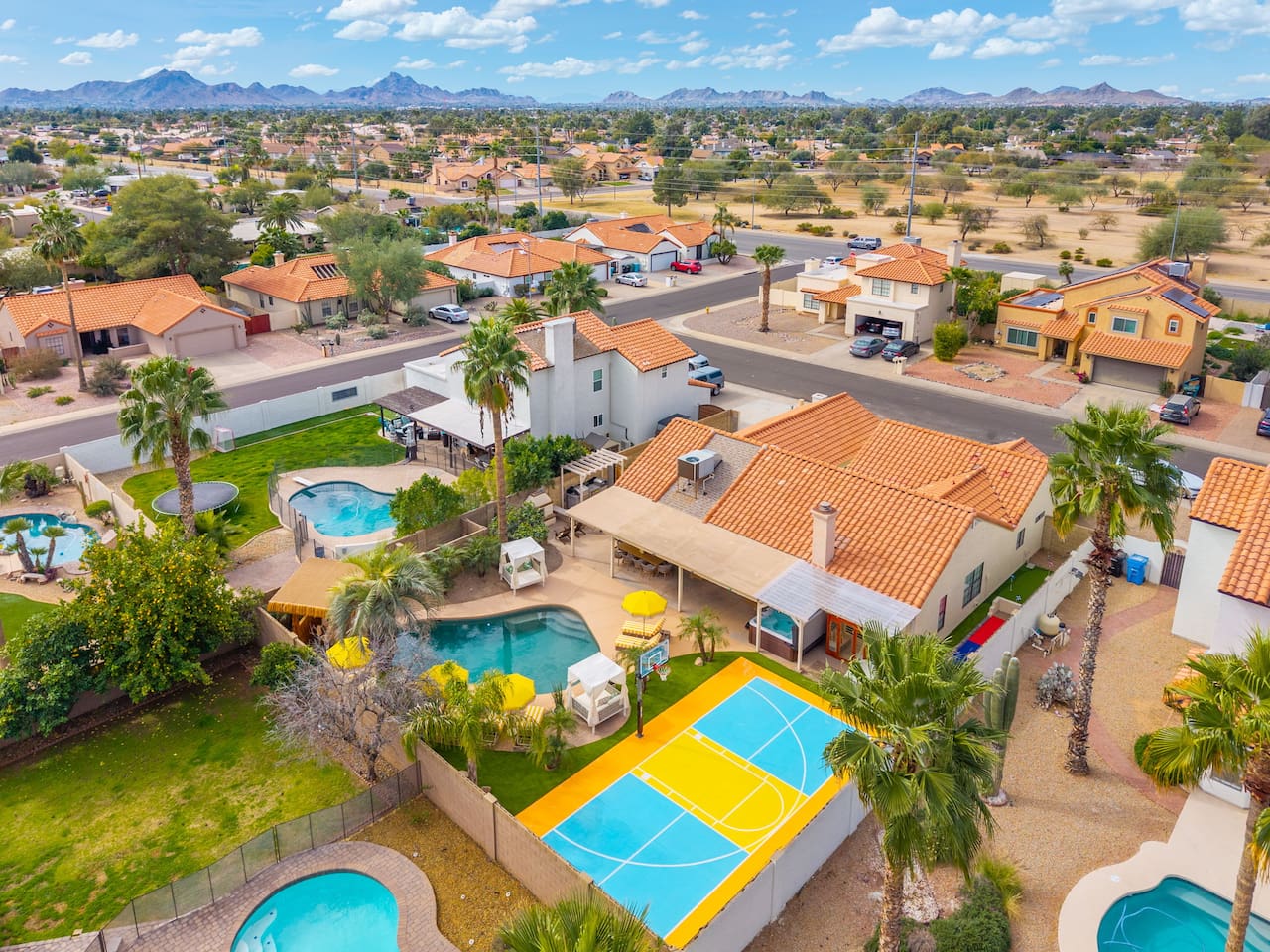 Aerial view of property with pools, sports courts, and desert mountain views—a premier Scottsdale vacation home with resort-style amenities.