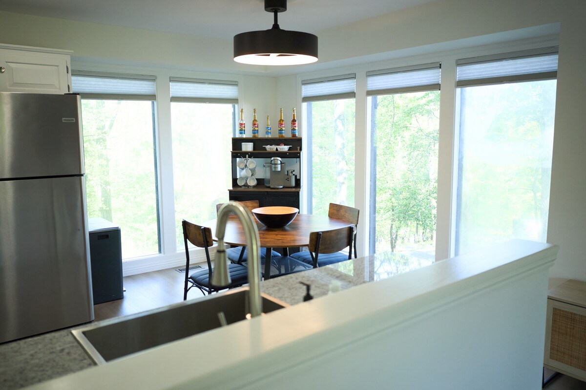 A bright dining space wrapped in windows, with treetop views from every seat.