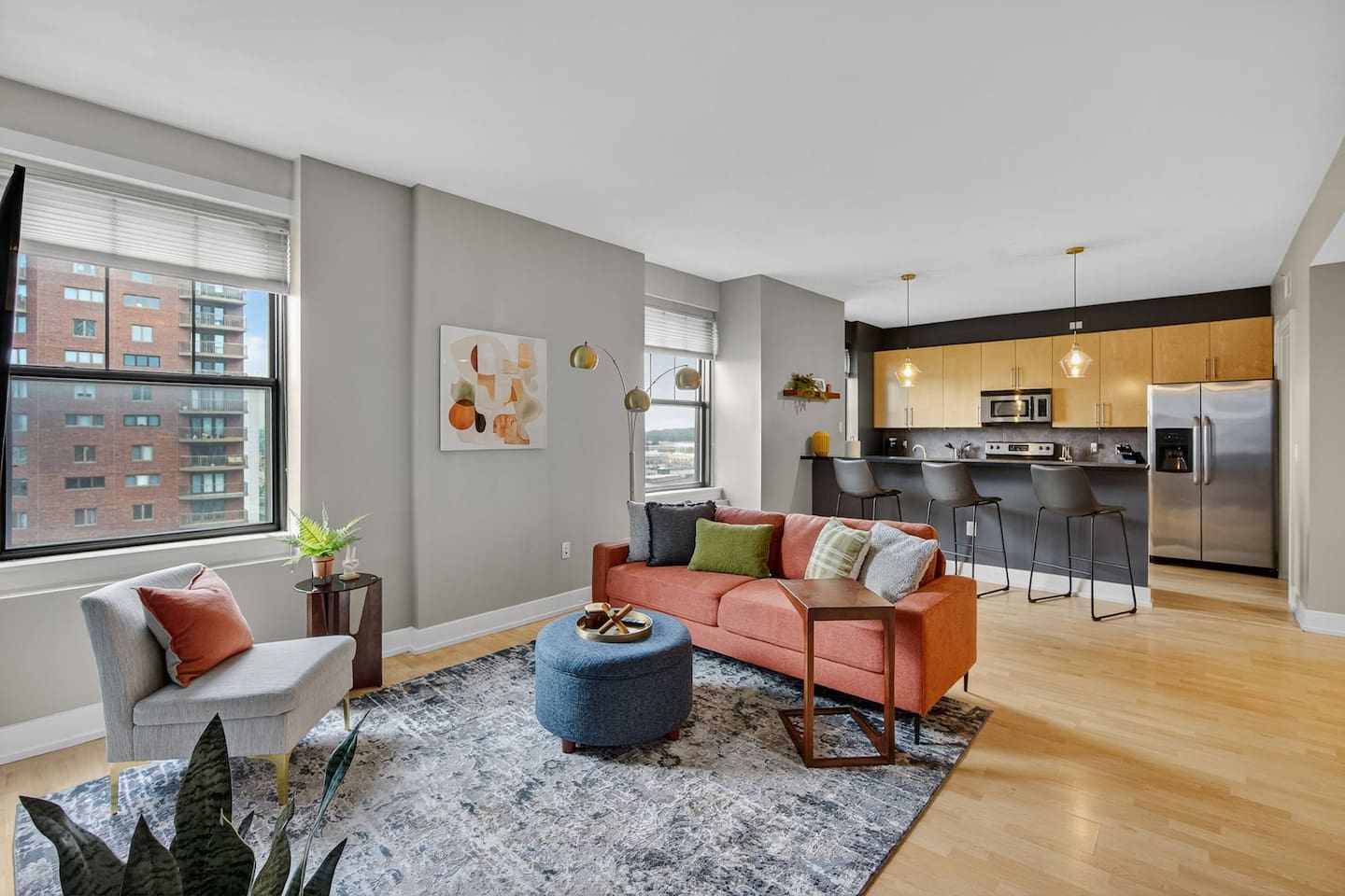 This open-concept space blends cozy comfort and modern convenience. Lounge on the sofa with colorful pillows, then cook a meal in the fully equipped kitchen with stainless appliances and bar seating; ideal for both entertaining and relaxing.