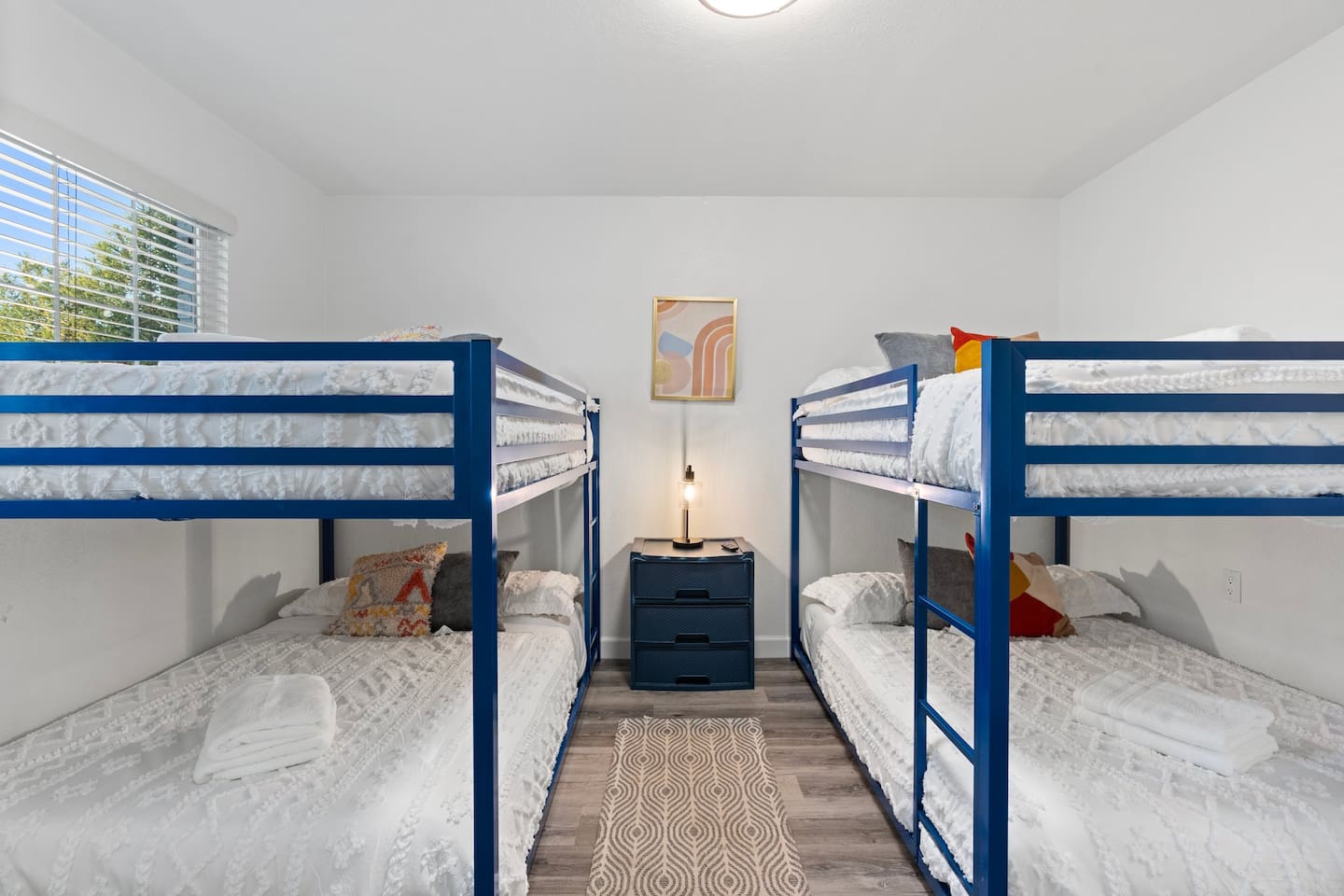 Natural light, vibrant art, and modern blue frames create a cheerful space that’s both fun and functional.