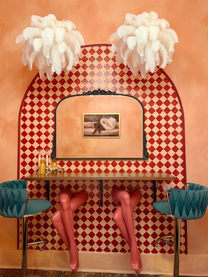 Playful glam vanity lounge with vintage feather lamps and statement art. The perfect  getting-ready spot for girls trips, bachelorette weekends, and nights out in the French  Quarter. 
